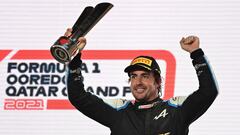 Alpine's Spanish driver Fernando Alonso raises his 3rd-place trophy on the podium following the Qatari Formula One Grand Prix at the Losail International Circuit, on the outskirts of the capital city of Doha, on November 21, 2021. (Photo by ANDREJ ISAKOVI
