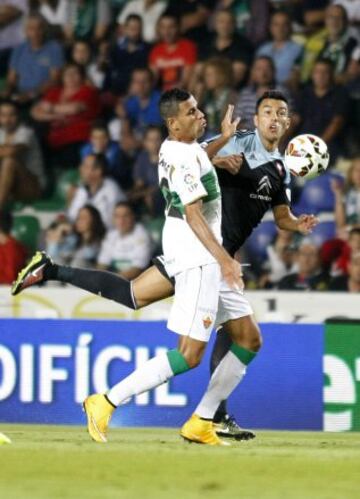 El defensa del Celta de Vigo Jonny Castro (d) lucha un balón con el delantero brasileño del Elche Jonathas de Jesus, durante el partido de la sexta jornada de liga de Primera División, disputado esta noche en el Estadio Martínez Valero.