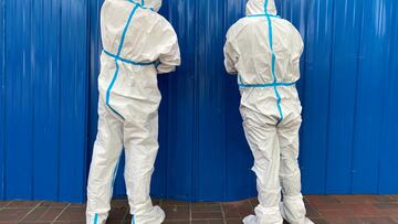 FILE PHOTO: Workers in protective suits set up barriers outside a building, following the coronavirus disease (COVID-19) outbreak, in Shanghai, China June 9, 2022. REUTERS/Andrew Galbraith/File Photo