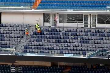 Operarios relizan diversas tareas en la instalación de butacas, vallas de vidrio y pantallas, así como cambios en la instalación de las bandejas del césped.