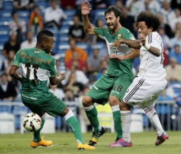 El centrocampista caboverdiano del Elche Garry Mendes Rodrigues y su compañero, el defensa Sergio Pellegrín luchan un balón con el defensa brasileño del Real Madrid Marcelo Vieira.