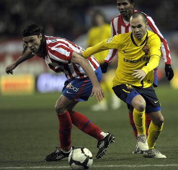 El jugador del Barcelona Iniesta trata de llevarse el balón ante el jugador del Atlético Ujfalusi. 