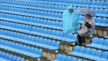 Dos espectadores se protegen ante la lluvia en Múnich.