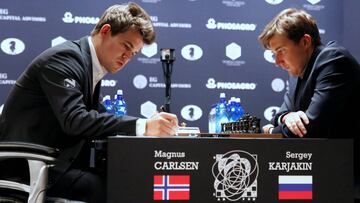 Magnus Carlsen, of Norway (L), takes notes during his match with Sergey Karjakin, of Russia, during their round 5 of the 2016 World Chess Championship in New York U.S., November 17, 2016. REUTERS/Shannon Stapleton