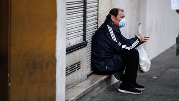 AME7097. BUENOS AIRES (ARGENTINA), 16/06/2020.- Un hombre protegido con tapabocas espera sentado durante una jornada de tomas de pruebas de coronavirus este martes, en el barrio Constituci&oacute;n de Buenos Aires (Argentina). Argentina registra 32.785 casos de contagios de covid-19, mientras que los fallecimientos suman 854. EFE/ Juan Ignacio Roncoroni