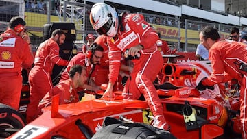 Ferrari's German driver Sebastian Vettel (C) gets out of his car before the start of the Formula One Japanese Grand Prix at Suzuka on October 8, 2017. / AFP PHOTO / Kazuhiro NOGI