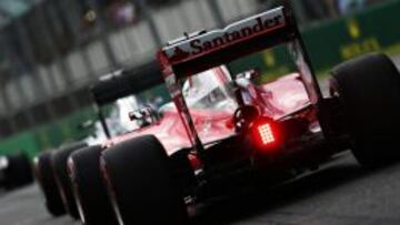 Sebastian Vettel y otros pilotos enfilan la salida del pit lane para afrontar la calificación.