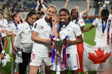 USWNT stars Lindsey Horan and Catarina Macario of Olympique Lyon celebrate with the UEFA Women's Champions League trophy.