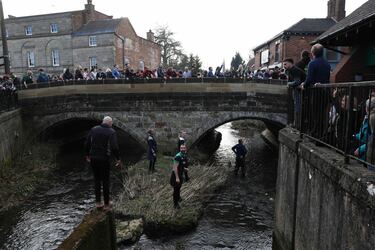 La gente espera que la pelota llegue al puente sobre Henmore Brook.