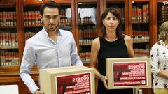 Alberto Contador y Anna Gonz&aacute;lez posan con dos cajas en las que muestran las 229.000 firmas recogidas Por Una Ley Justa en su encuentro con la ministra de Justicia Dolores Delgado este lunes en la sede del Ministerio de Justicia en Madrid.