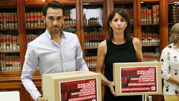 Alberto Contador y Anna Gonz&aacute;lez posan con dos cajas en las que muestran las 229.000 firmas recogidas Por Una Ley Justa en su encuentro con la ministra de Justicia Dolores Delgado este lunes en la sede del Ministerio de Justicia en Madrid.