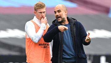 Guardiola y De Bruyne charlan durante un partido del City.