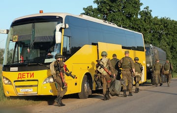 Los miembros del servicio ruso ocupan posiciones, como parte de una operación declarada después de un motín armado por parte del grupo mercenario Wagner, en la región de Moscú. Un cartel en un autobús dice: "Niños". 