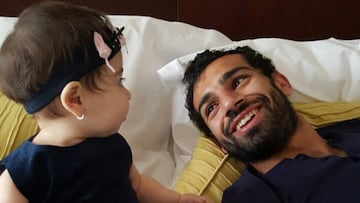 Mohamed Salah tumbado en la cama y mirando sonriente a su hija Makka