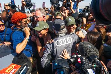 El piloto español del equipo Audi Sport Carlos Sainz es felicitado por su hijo, el piloto de Fórmula 1 Carlos Sainz Jr. y su esposa Reyes Vázquez de Castro, después de cruzar la línea de meta de la etapa 12 de Yanbu a Yanbu, y conseguir su cuarto Rally Dakar.
