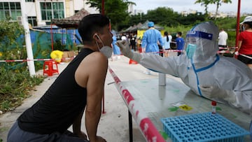 A medical worker takes a swab sample from a resident for the nucleic acid test at a makeshift testing site, amid lockdown measures to curb the coronavirus disease (COVID-19) outbreak in Sanya, Hainan province, China August 9, 2022. China Daily via REUTERS ATTENTION EDITORS - THIS IMAGE WAS PROVIDED BY A THIRD PARTY. CHINA OUT.