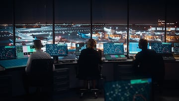 Diverse Air Traffic Control Team Working in a Modern Airport Tower at Night. Office Room is Full of Desktop Computer Displays with Navigation Screens, Airplane Flight Radar Data for Controllers.