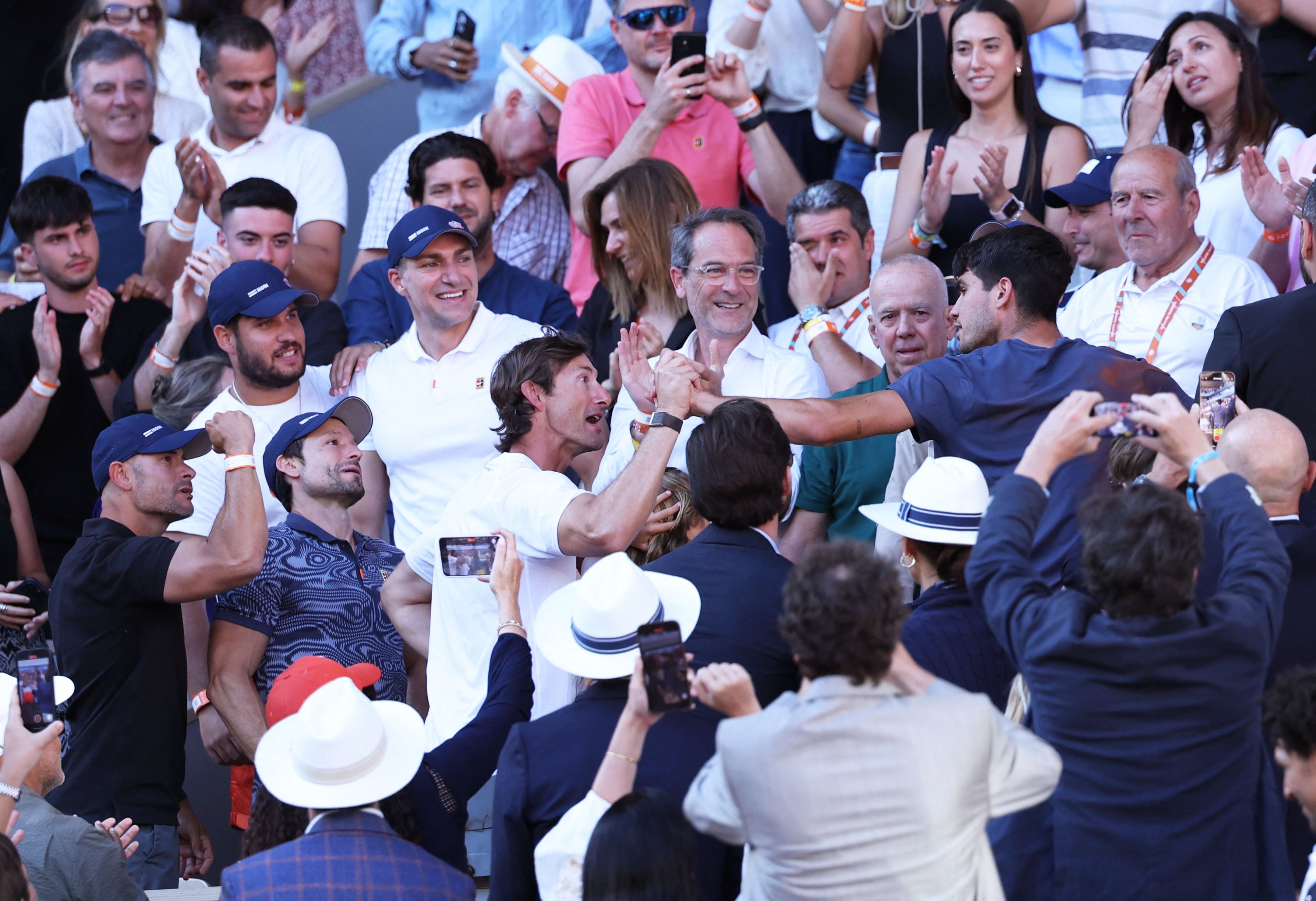 Spain's Carlos Alcaraz (R) celebrates with his coach Juan Carlos Ferrero and team after winning against Germany's Alexander Zverev at the end of their men's singles final match on Court Philippe-Chatrier on day fifteen of the French Open tennis tournament at the Roland Garros Complex in Paris on June 9, 2024. (Photo by ALAIN JOCARD / AFP)
