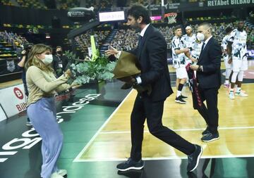 Homenaje del Bilbao Basket a Cortizas, con Mumbrú entregando flores a la hija del periodista, June