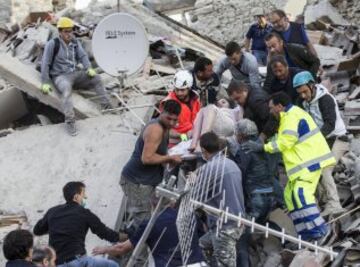 ITA12 AMATRICE (ITALIA) 24/08/2016.- Una mujer herida es rescatada de entre los escombros de un edificio en Amatrice, en el centro de Italia, hoy, 24 de agosto de 2016. Al menos 19 personas han fallecido y hay decenas de heridos tras el terremoto de 6 grados en la escala Richter que ha sacudido el centro de Italia esta madrugada, según informó la televisión pública RAI. EFE/Massimo Percossi