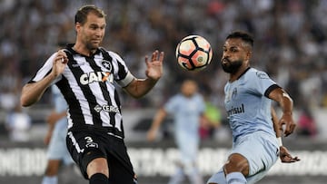 Joel Carli of Brazil's Botafogo (L) vies for the ball with Fernandinho of Gremio during their Copa Libertadores 2017 football match at Nilton Santos stadium on September 13, 2017 in Rio de Janeiro, Brazil. / AFP PHOTO / Apu Gomes