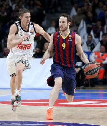 El base italiano del FC Barcelona Marcelinho Huertas, con el balón ante el escolta estadounidense del Real Madrid Jaycee Carroll durante el partido del Top-16 de la Euroliga, Grupo E, disputado esta tarde en el Palacio de los Deportes de la Comunidad de Madrid. 