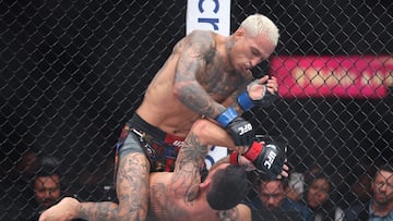 LAS VEGAS, NEVADA - MARCH 07: Charles Oliveira of Brazil strikes Max Holloway of the United States during their BMF title bout at T-Mobile Arena on March 07, 2026 in Las Vegas, Nevada. Sean M. Haffey/Getty Images/AFP (Photo by Sean M. Haffey / GETTY IMAGES NORTH AMERICA / Getty Images via AFP)
