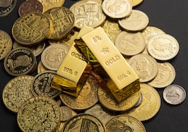 Golden coins, and gold bars scattered on a table