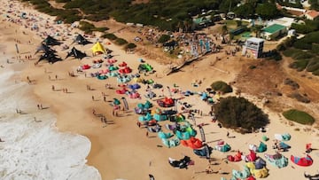 Vista a&eacute;rae de la playa de Valdevaqueros (Tarifa, C&aacute;diz, Espa&ntilde;a), en verano del 2022, durante la celebraci&oacute;n de la Spain Kiteboarding League, con ba&ntilde;istas y cometas y el chiringuito de El Tumbao. 