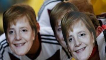 Aficionados alemanes, con la m&aacute;scara de Angela Merkel durante un partido del Mundial. 