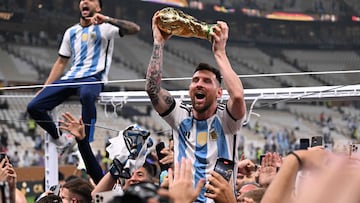 Argentina's forward #10 Lionel Messi lifts the FIFA World Cup Trophy as he celebrateswith supporters winning the Qatar 2022 World Cup final football match between Argentina and France at Lusail Stadium in Lusail, north of Doha on December 18, 2022. (Photo by Kirill KUDRYAVTSEV / AFP)