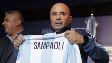 Argentina's new soccer coach Jorge Sampaoli holds up a jersey featuring his name at the end of a press conference in Buenos Aires, Argentina, Thursday, June 1, 2017. (AP Photo/Natacha Pisarenko)