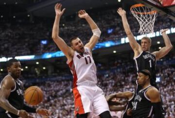 El jugador de los Toronto Raptors, Jonas Valanciunas, pierde el balón ante los jugadores de los Brooklyn Nets.