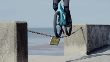 El piloto de MTB y Street Trial Danny MacAskill con su bici sobre una cadena de No Access que da a un espigón.