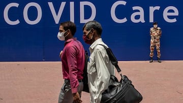 Workers walk past an Indo-Tibetan Border Police (ITBP) officer at the campus of Radha Soami Satsang Beas, a spiritual organization, where a coronavirus disease (COVID-19) care centre has been constructed for the patients amidst the spread of the disease,