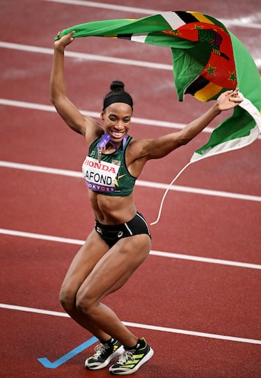 La dominicana Thea Lafond, medallista de plata, celebra con una bandera de Dominica tras la final.