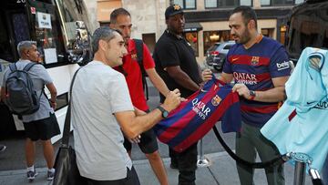 El entrenador Ernesto Valverda firma una camiseta a un aficionado del Barcelona a la llegada de la expedición azulgrana a Estados Unidos.
