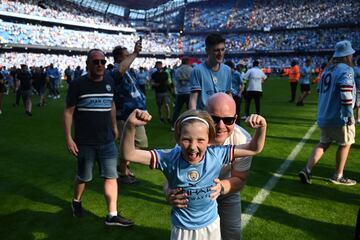 Los seguidores del Manchester City invaden el campo durante las celebración por el título después del partido de fútbol de la Premier League inglesa contra el Chelsea.
 

