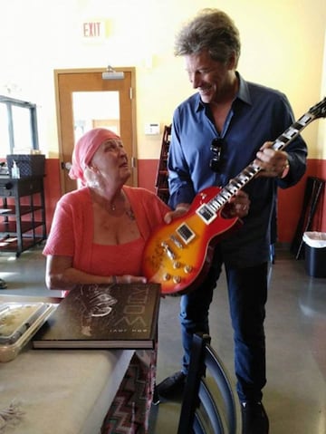 Jon Bon Jovi con Carol Cesario y la guitarra y el libro que le regaló.  @Rosie Skripkunis