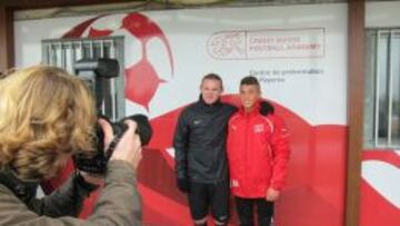 Wayne Rooney fotografiado con uno de los j&oacute;venes con los que entren&oacute; en Suiza.