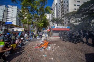 Miembros de la Policía brasileña dispersan a un grupo de manifestantes, durante la primera protesta contra el Mundial de fútbol Brasil 2014 registrada en Sao Paulo (Brasil), en el día en que comienza la competición. Cerca de 150 hombres de la Tropa de Choque de la Policía Militarizada del estado de Sao Paulo dispersaron a un grupo de 50 manifestantes que intentaba marchar por la avenida Radial Este, la principal vía de acceso al Arena Corinthians, el estadio de Sao Paulo en que se disputará el partido inaugural del Mundial.