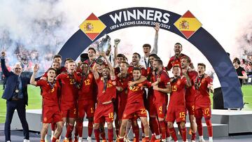 Spain's players and Spain's coach Luis de la Fuente (L) celebrate on the podium with the UEFA Nations League cup after winning the penalty shootouts and the UEFA Nations League final football match between Croatia and Spain at the De Kuip Stadium in Rotterdam on June 18, 2023. (Photo by JOHN THYS / AFP)