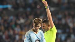 El colegiado andaluz Figueroa Vázquez amonesta con una tarjeta amarilla a Williot Swedberg durante el partido entre el Celta y Osasuna.