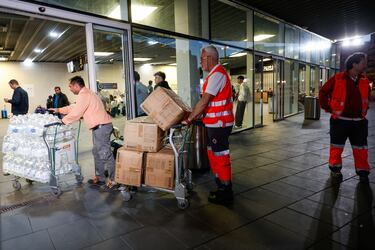 Miembros de Cruz Roja acuden con mantas y agua a la estación Joaquín Sorolla, en Valencia, para ayudar a los viajeros que deberán pasar la noche en la estación.