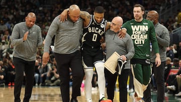 Damian Lillard #0 of the Milwaukee Bucks is helped off the court after an apparent injury during the first quarter in Game Four of the Eastern Conference First Round NBA Playoffs against the Indiana Pacers at Fiserv Forum on April 27, 2025 in Milwaukee, Wisconsin.