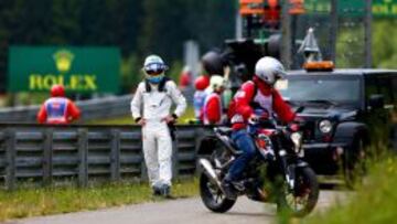 Fernando Alonso espera tras su accidente en Austria.