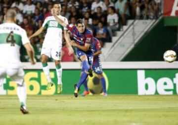 El centrocampista del Eibar Dani García (d) lanza a puerta para conseguir el primer gol de su equipo, durante el encuentro de la cuarta jornada de Liga de Primera División que Elche y Eibar juegan esta noche en el estadio Martínez Valero, en Elche.