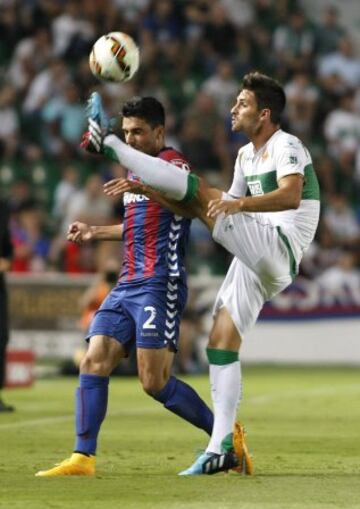 El centrocampista del Elche, Adrián González (d), despeja la pelota ante el defensa del Eibar, Eneko Bóveda (i), durante el encuentro de la cuarta jornada de Liga de Primera División que se juega esta noche en el estadio Martínez Valero, en Elche. 