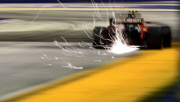 Sparks fly as McLaren's Belgian driver Stoffel Vandoorne drives during the qualifying session of the Formula One Singapore Grand Prix in Singapore on September 16, 2017. / AFP PHOTO / Manan VATSYAYANA