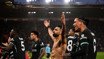 Liverpool's Egyptian striker #11 Mohamed Salah (C) celebrates with teammates and supporters after shooting a penalty kick and scoring his team third goal during the English Premier League football match between Southampton and Liverpool at St Mary's Stadium in Southampton, southern England on November 24, 2024. (Photo by JUSTIN TALLIS / AFP) / RESTRICTED TO EDITORIAL USE. No use with unauthorized audio, video, data, fixture lists, club/league logos or 'live' services. Online in-match use limited to 120 images. An additional 40 images may be used in extra time. No video emulation. Social media in-match use limited to 120 images. An additional 40 images may be used in extra time. No use in betting publications, games or single club/league/player publications. /